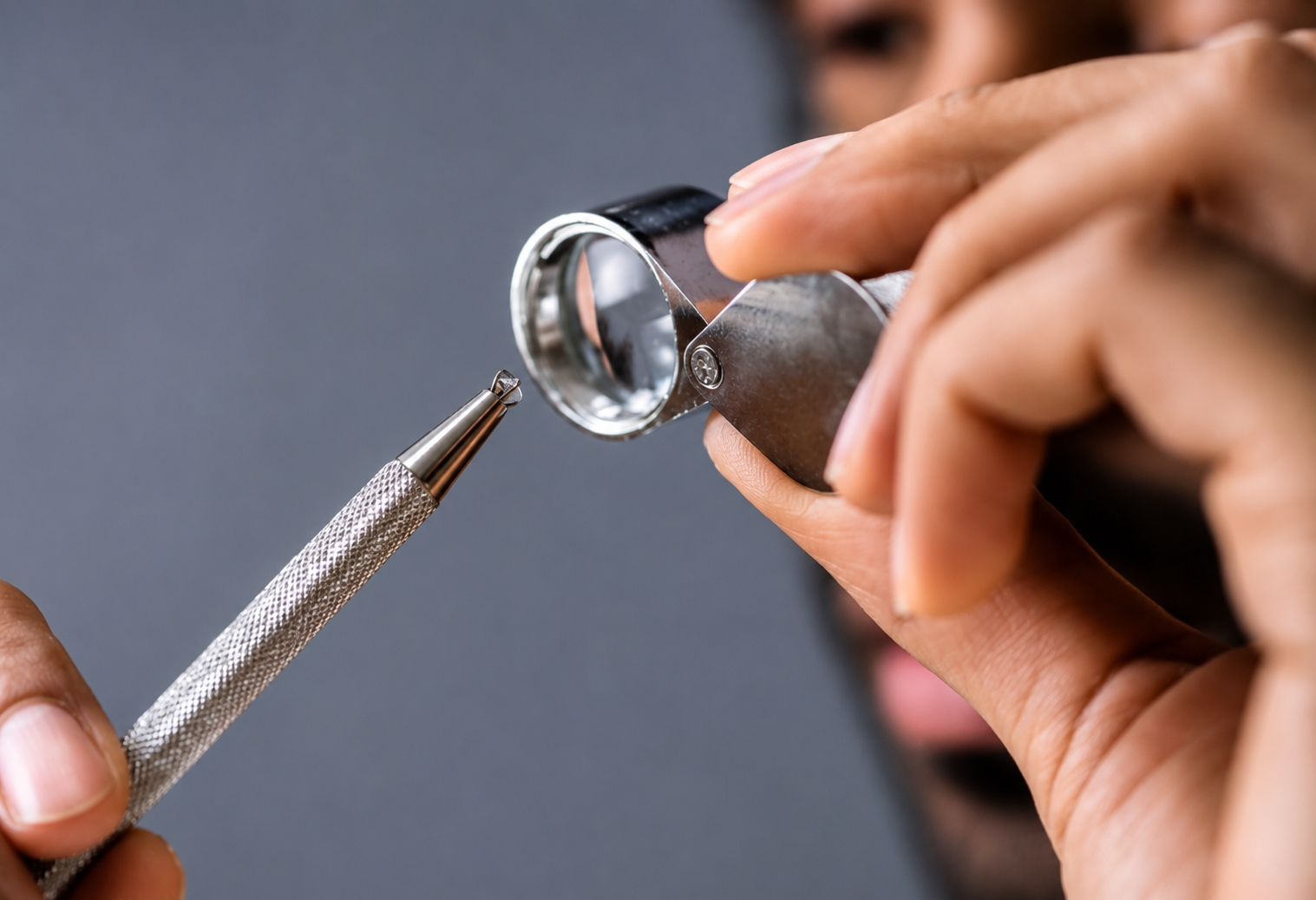 A man checking whether the stone is natural or fake using lens.