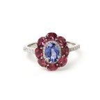 Elegant sterling silver ring with blue tanzanite center and pink gemstone halo, accented with diamonds