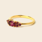 Gold ring with red gemstones on a white background