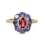 Elegant gold ring with oval pink tourmaline, surrounded by blue tanzanite and diamond accents, perfect for fine jewelry lovers.