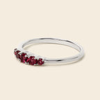 Silver ring with red gemstones on a white background