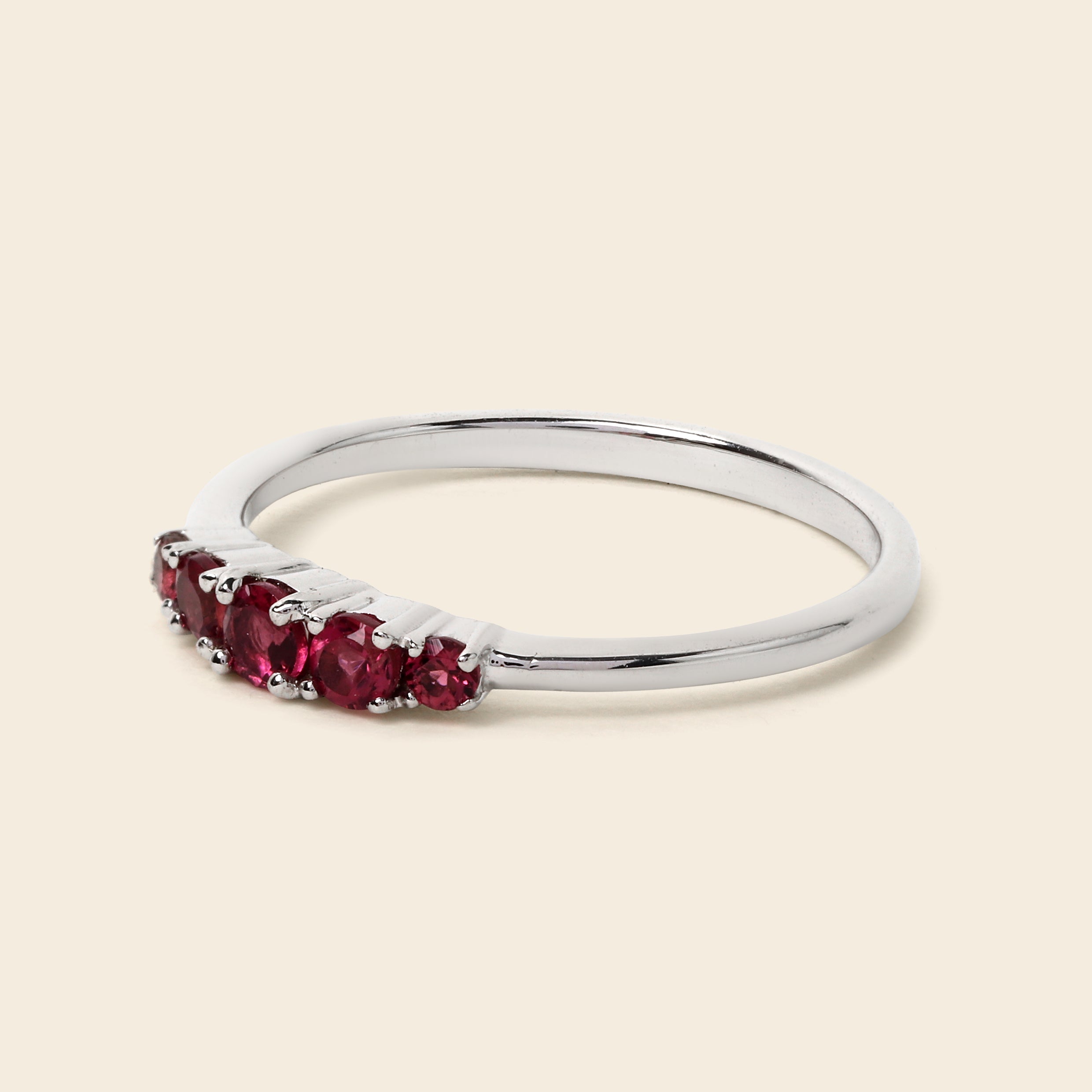 Silver ring with red gemstones on a white background