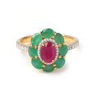 Elegant gold ring with oval ruby center, surrounded by emeralds and diamonds, perfect for luxury gemstone jewelry.