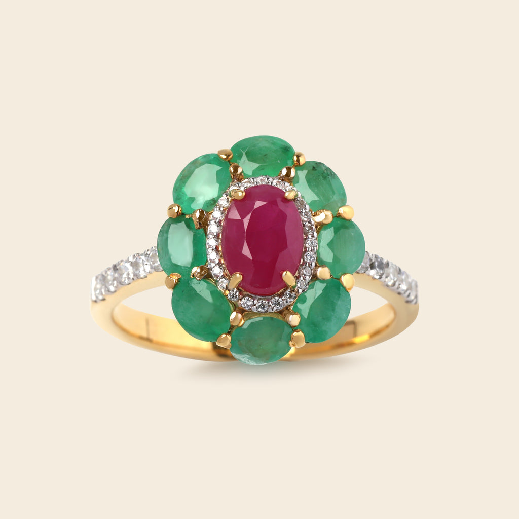 A yellow gold ring featuring a central oval pinkish-red gemstone surrounded by a halo of green oval gemstones, with a band set with small clear stones, shown on a light beige background.