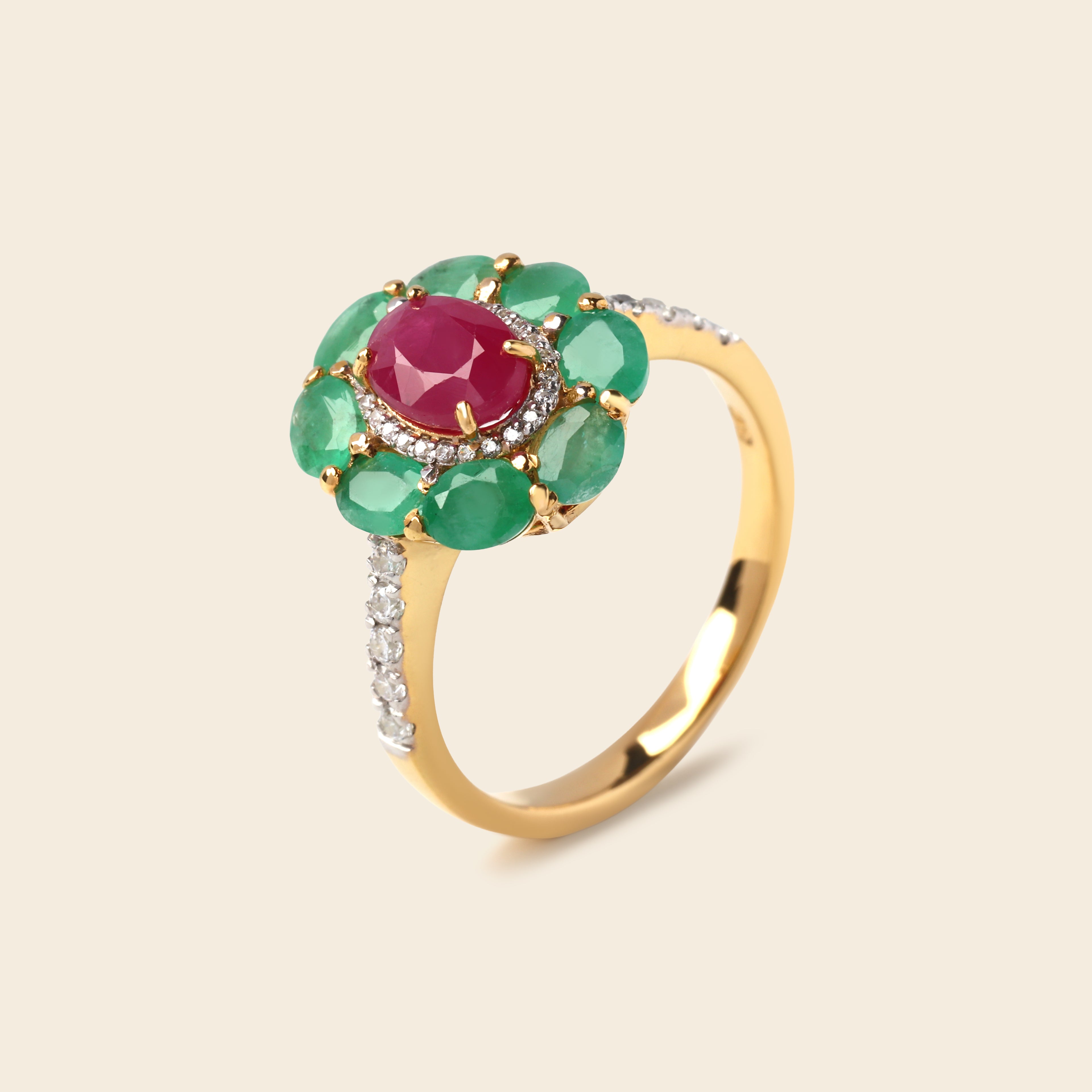 A yellow gold ring featuring a central oval pinkish-red gemstone surrounded by a halo of green oval gemstones, with a pavé-set silver band adorned with small clear stones.