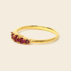 Gold ring with red gemstones on a white background