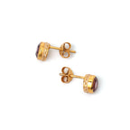 Gold-plated stud earrings with purple gemstones and white enamel detailing, elegant handmade jewelry