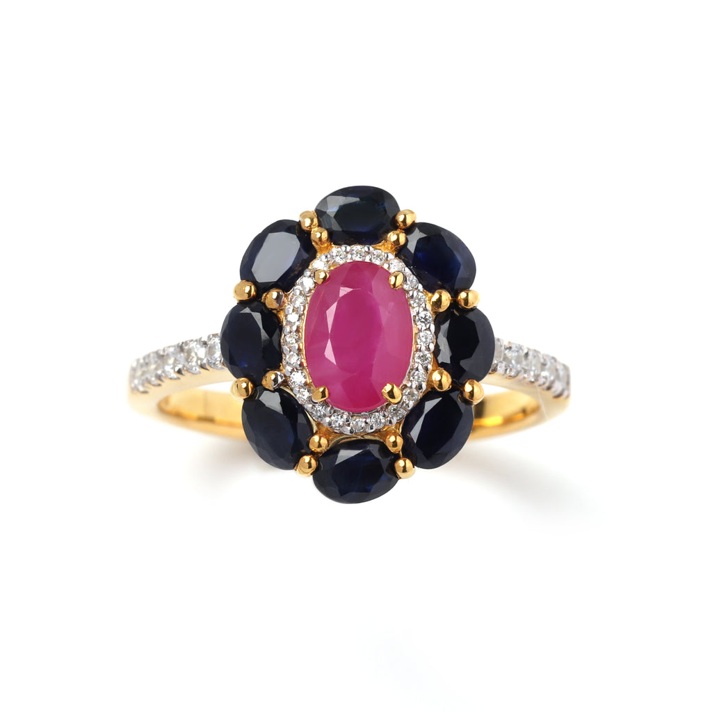 Close-up of ruby and sapphire halo ring in 925 sterling silver with gold finish by Jewelry by Crimson