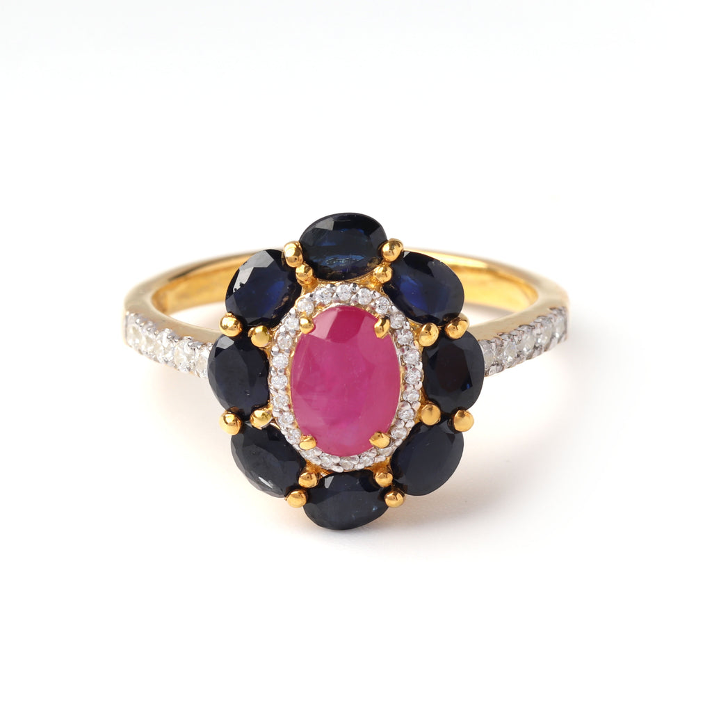 Close-up of ruby and sapphire halo ring in 925 sterling silver with gold finish by Jewelry by Crimson