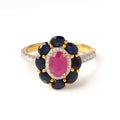 Close-up of ruby and sapphire halo ring in 925 sterling silver with gold finish by Jewelry by Crimson