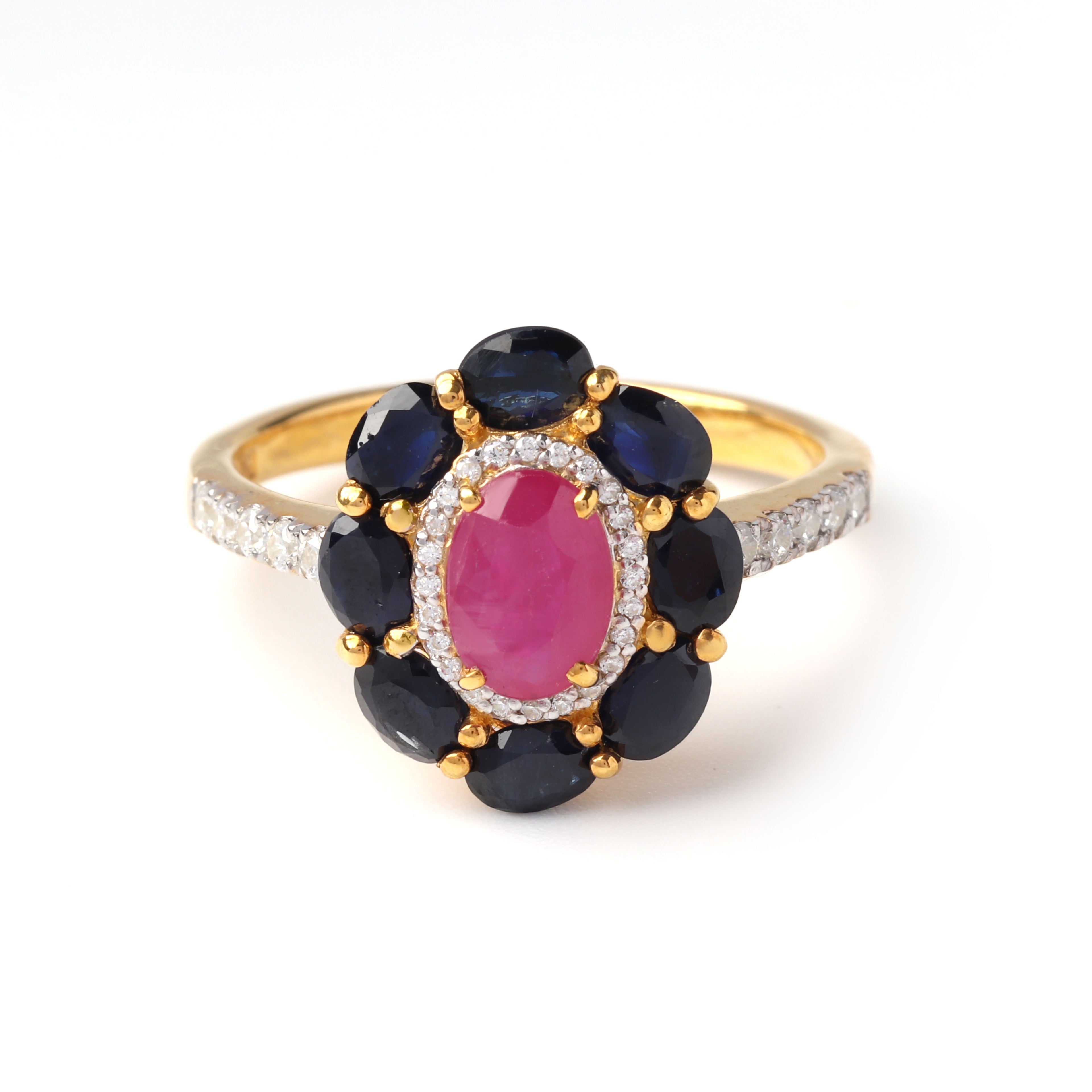 Close-up of ruby and sapphire halo ring in 925 sterling silver with gold finish by Jewelry by Crimson