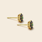 Gold earrings with green gemstones on a white background