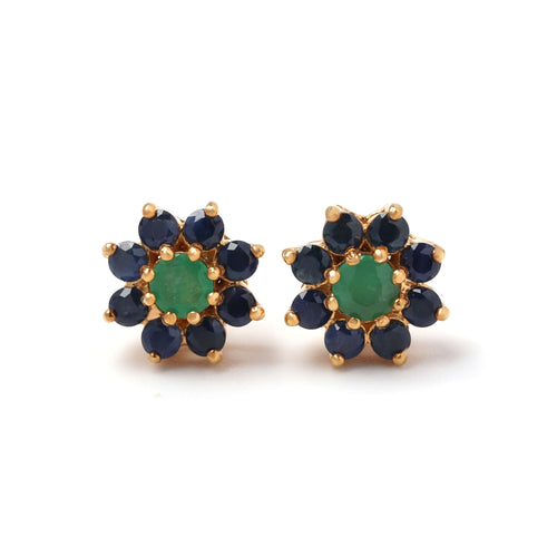 Close-up of emerald and blue sapphire stud earrings in 925 sterling silver with gold finish by Jewelry by Crimson