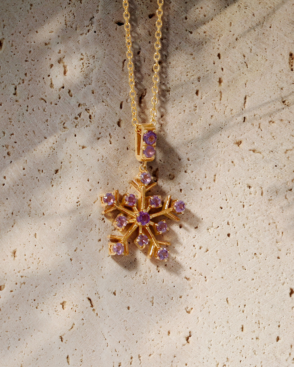 Amethyst gemstone snowflake pendant in gold — side view