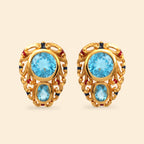 Gold-tone stud earrings with blue topaz and red/blue gem accents, ornate filigree design
