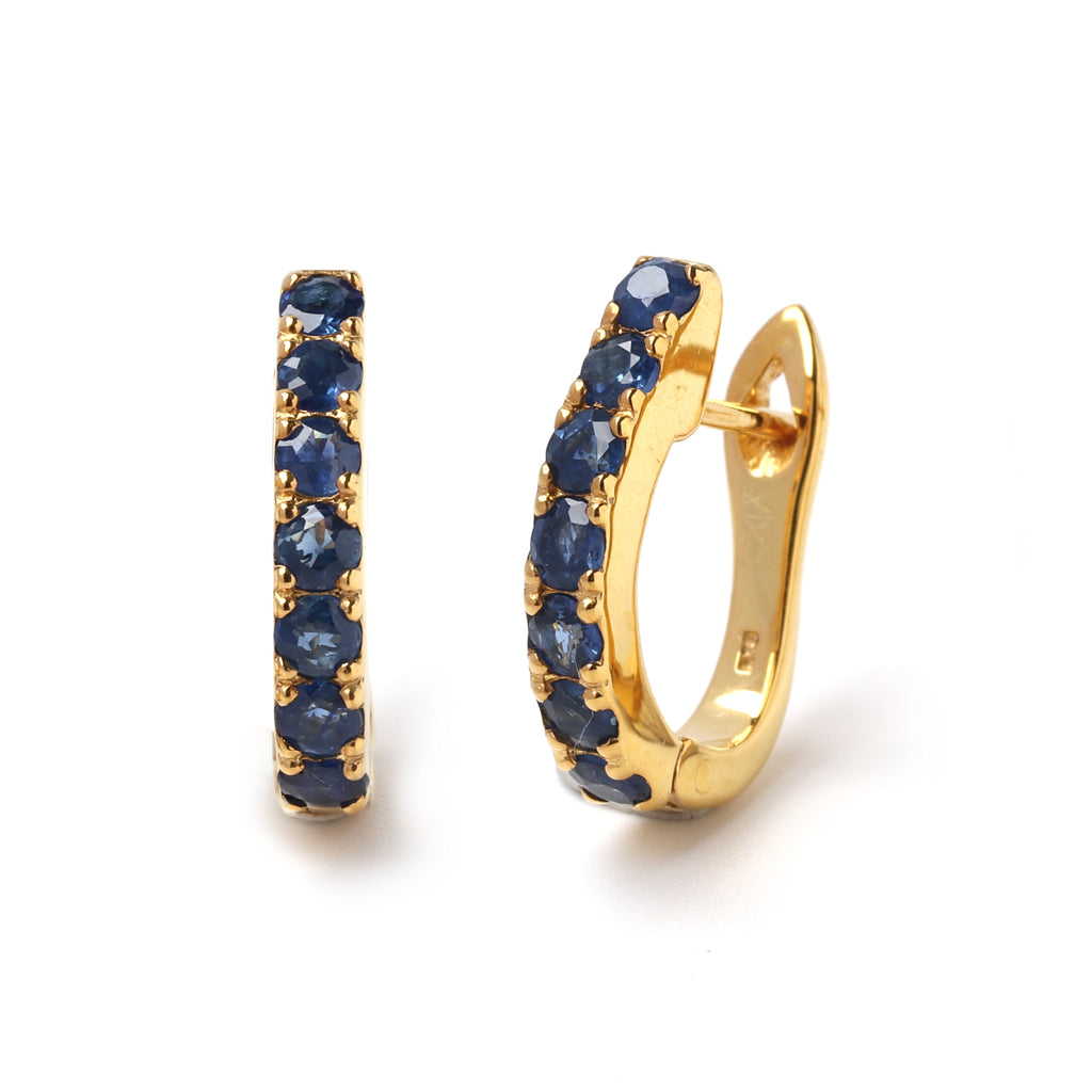 Close-up of 925 sterling silver sapphire hoop earrings with gold finish and prong-set blue sapphires by Jewelry by Crimson