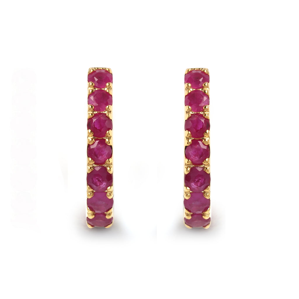 Detail of prong-set ruby stones on gold-finished 925 sterling silver hoop earrings