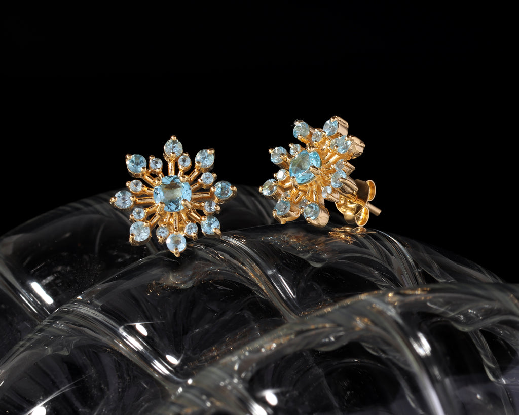 Blue topaz snowflake stud earrings in 18K gold — display view