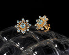 Blue topaz snowflake stud earrings in 18K gold — display view