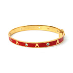 Gold bangle with red enamel, clover motifs, and clear gemstones, elegant women's jewelry