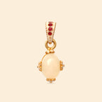 Elegant gold pendant with creamy oval gemstone and red accents, handcrafted jewelry design