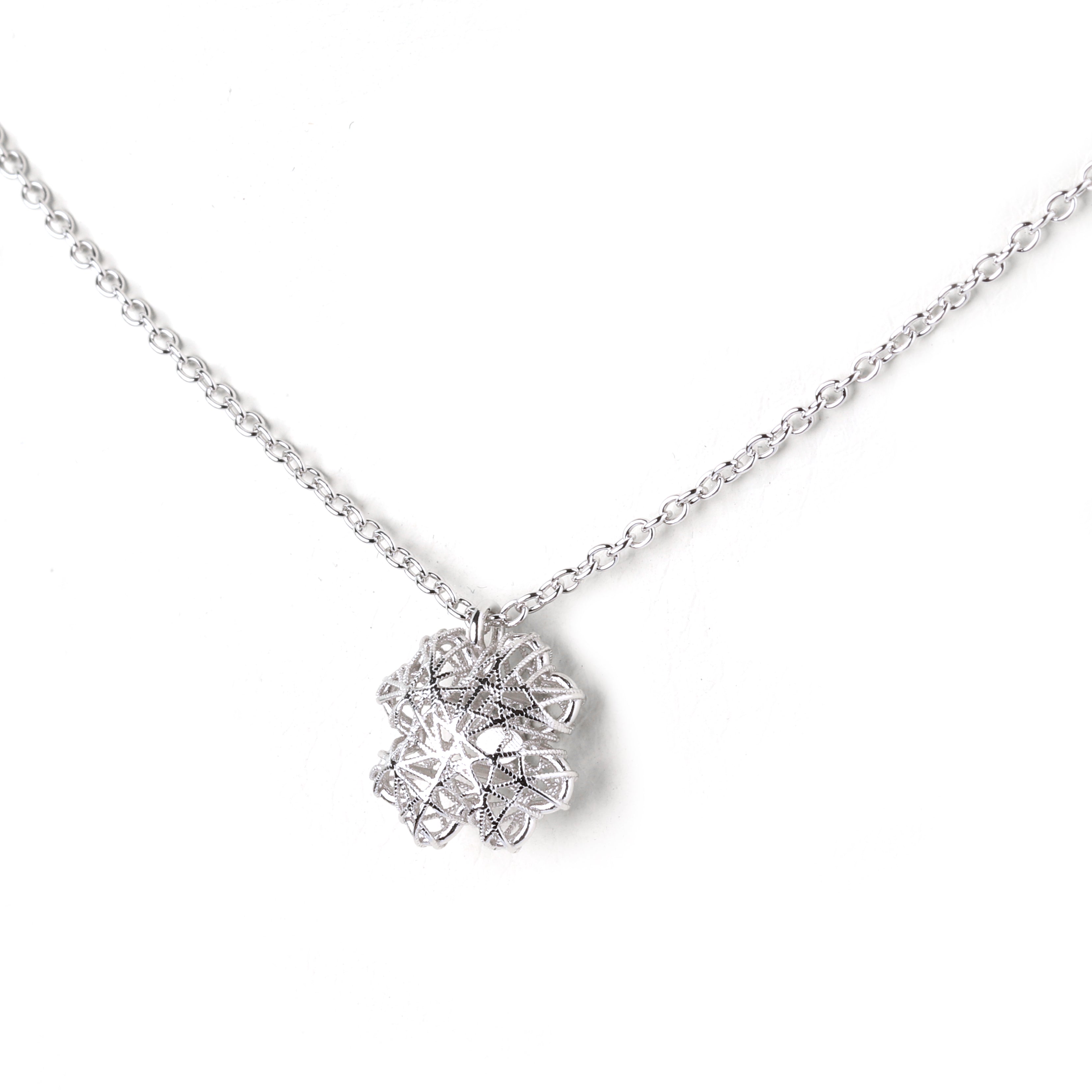 Detailed view of floral mandala silver pendant with high-polish finish
