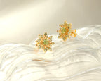 Green peridot snowflake earrings in gold — side view