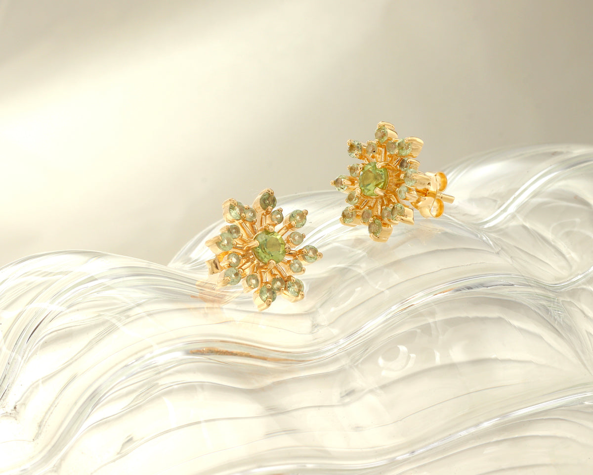 Green peridot snowflake earrings in gold — side view