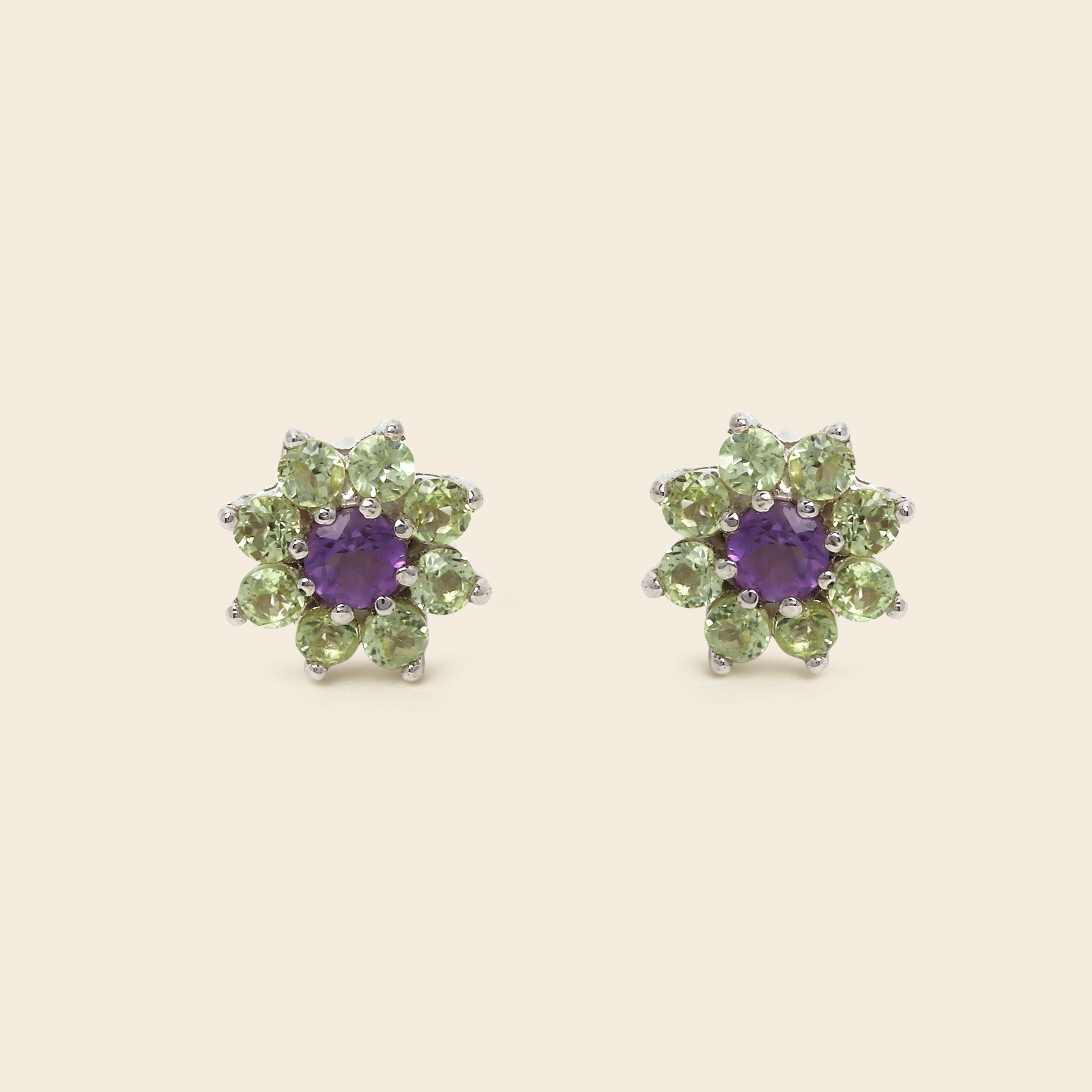 Floral-shaped green gemstone earrings on a white background