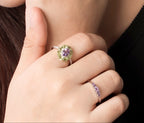 A close-up lifestyle shot of a woman wearing multiple rings and a small earring. 
