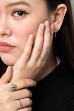 The rings feature small green and purple gemstone accents.