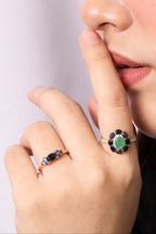 A close-up lifestyle shot of a person's hand and lower face wearing two silver rings. 