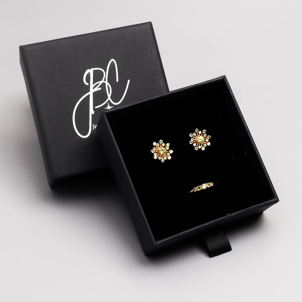 Peridot snowflake stud earrings in 18K gold — display view