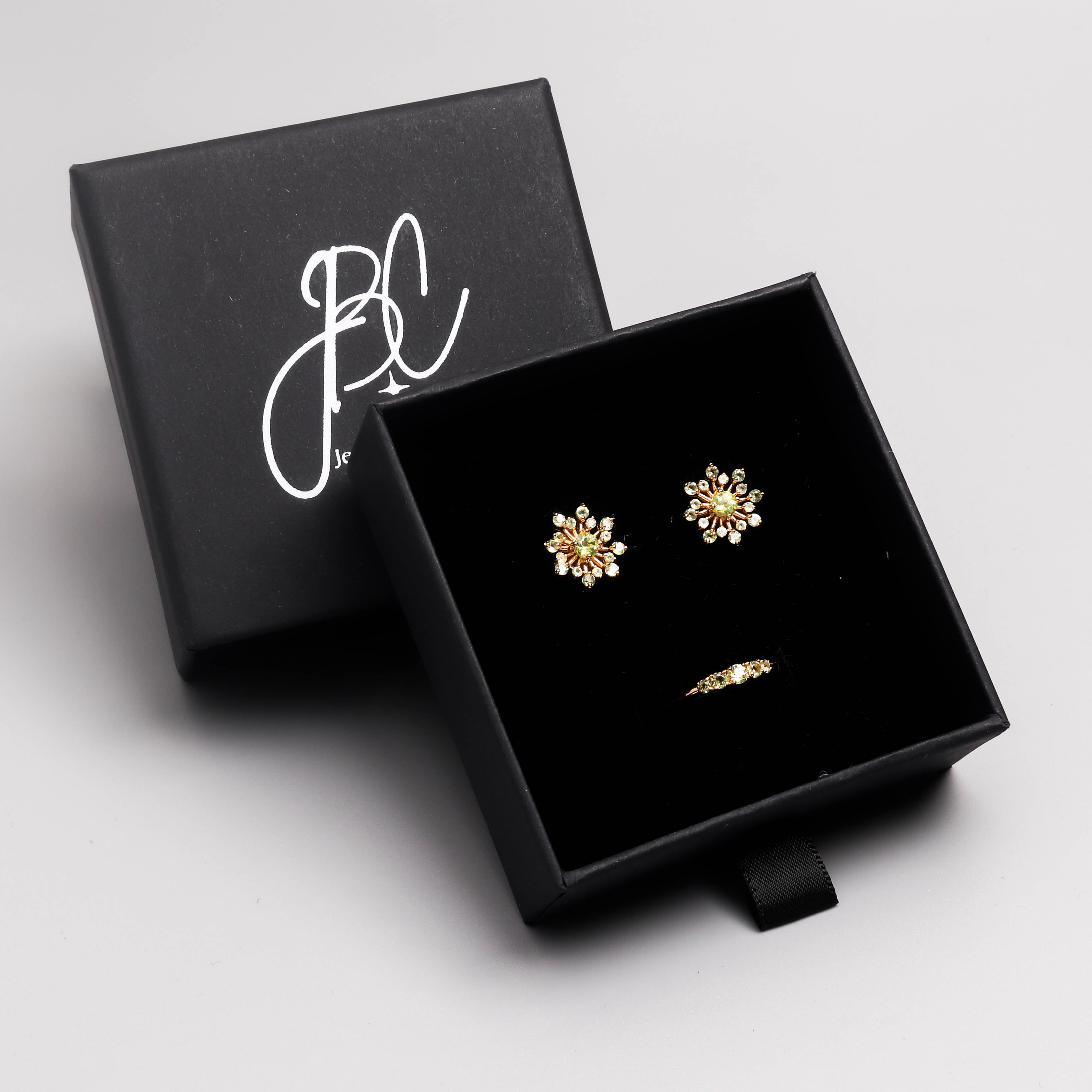 Peridot snowflake stud earrings in 18K gold — display view