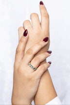 A close-up of two hands with dark burgundy manicured nails, with one hand resting on the other.