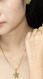 Gold snowflake pendant necklace with green gemstones, matching earrings and ring, elegant women's jewelry set