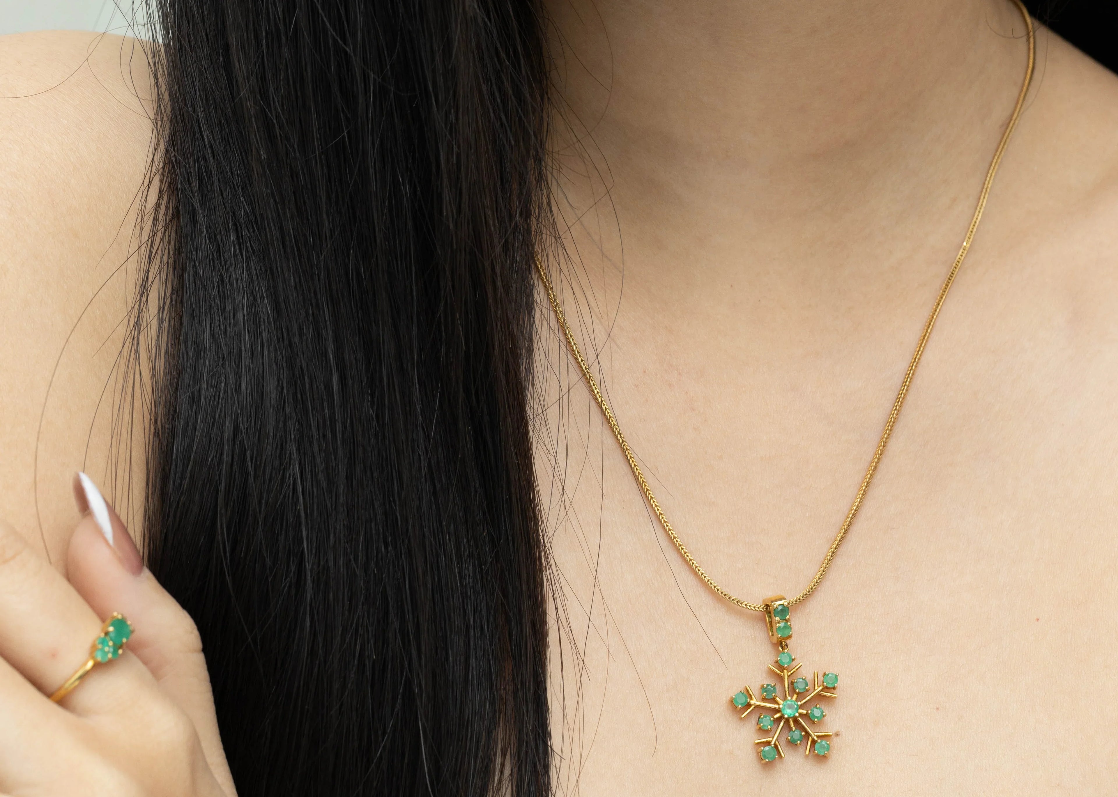 Elegant snowflake pendant with green emerald gemstones