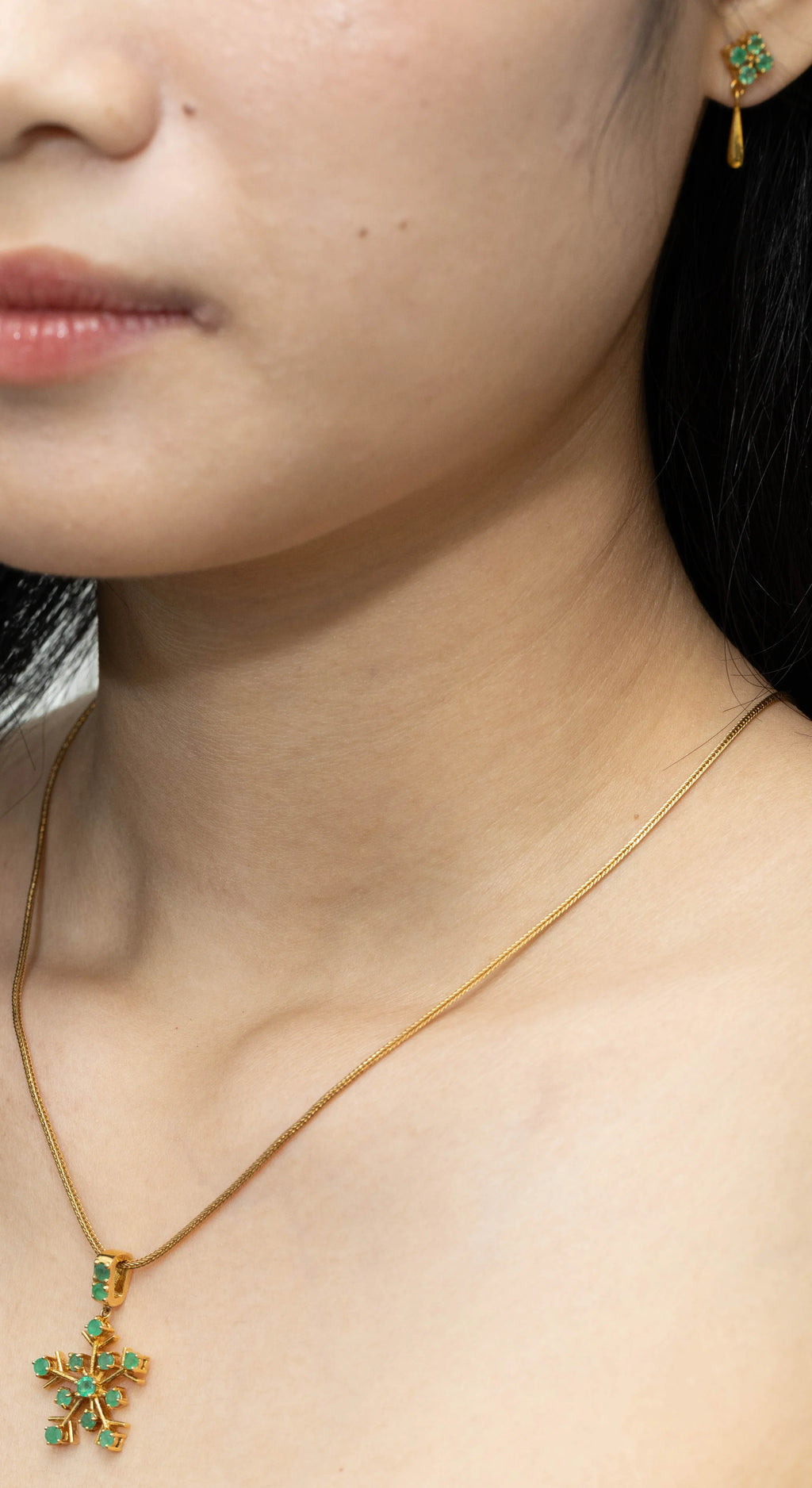 Gold necklace with emerald snowflake pendant and matching earrings, elegant gemstone jewelry