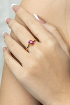 Gold ring with oval pink gemstone on woman's hand, elegant handmade jewelry