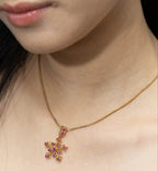 Gold snowflake pendant necklace with pink gemstones, elegant women's jewelry