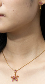 Gold snowflake pendant necklace with pink gemstones, elegant women's jewelry
