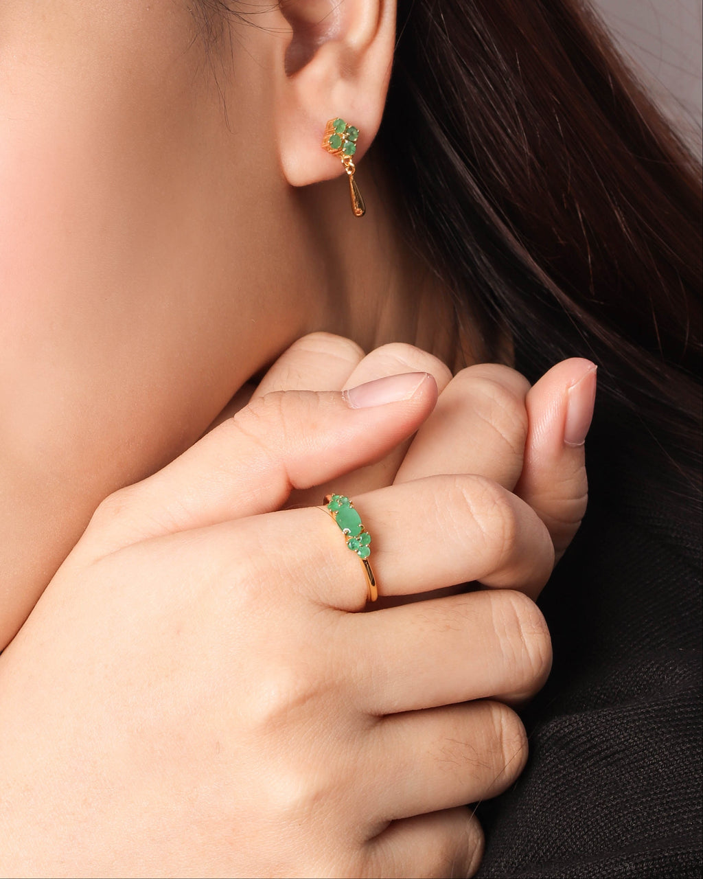 A gold earring emerald gemstones. 