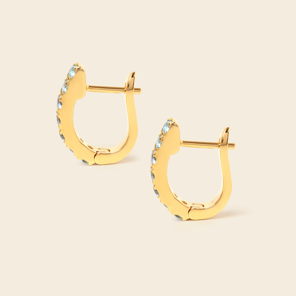 Blue topaz gemstone huggie hoops in 18K gold — detail view