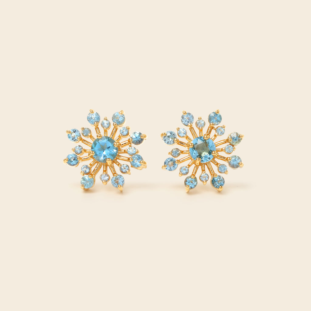 Blue topaz snowflake studs in 18K gold — detail view