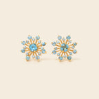 Blue topaz snowflake studs in 18K gold — detail view