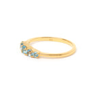 Round blue topaz five stone band ring in gold — detail view