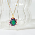 Emerald center with sapphire and ruby petals — flower pendant front view