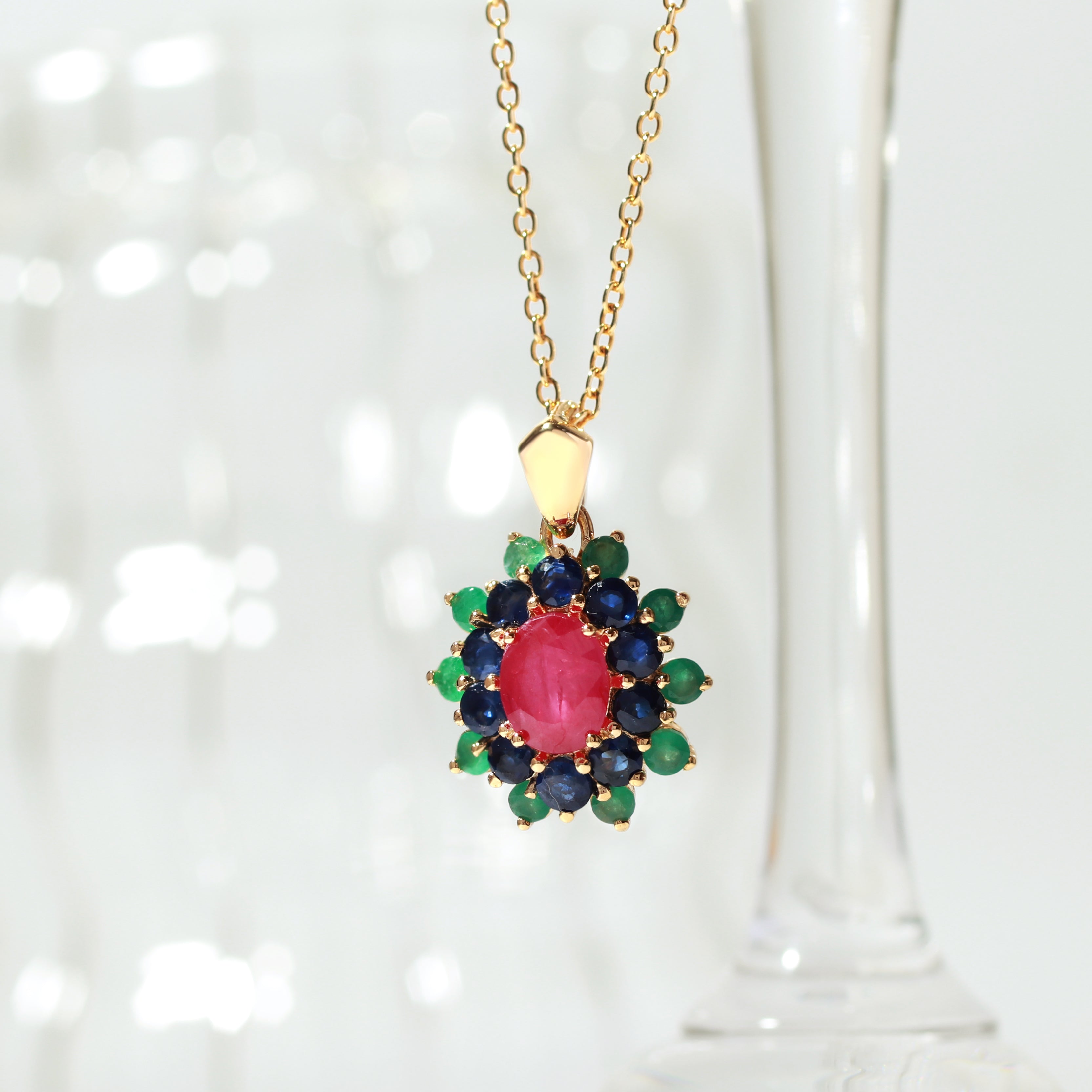 Ruby center with sapphire and emerald petals — flower pendant front view