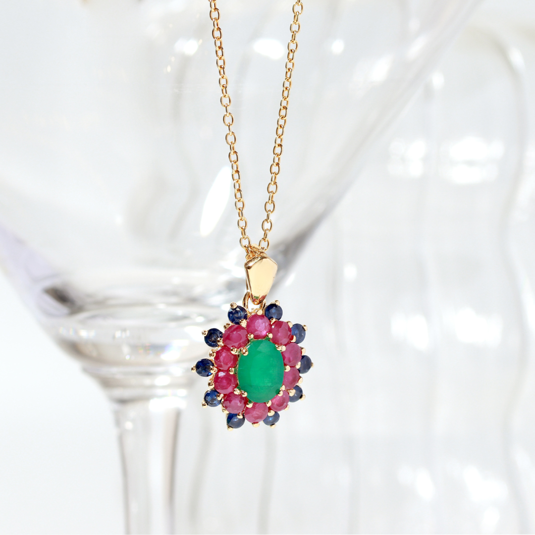 Emerald center with ruby and sapphire petals — flower pendant front view
